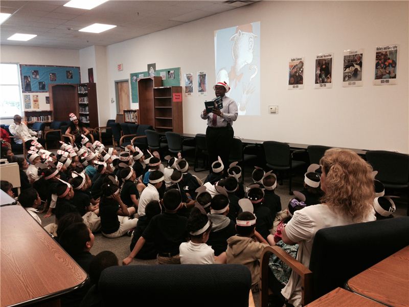 Mr. Will Henry, Director, reading "the Cat in the Hat" to the students and getting into character.